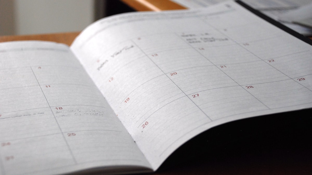 UK University Clearing After Panhellenic Exams 1 Open monthly planner on a desk, representing the June to September UK Clearing timeline