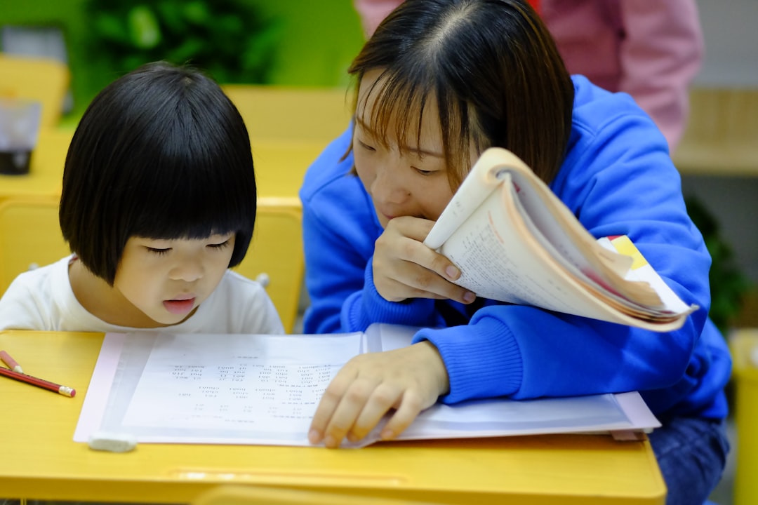 A tutor sitting with a student, going through study materials together