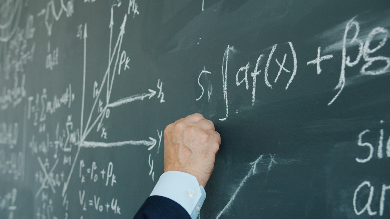 Hand underlining a maths equation on a chalkboard, GCSE-style algebra worked through step by step