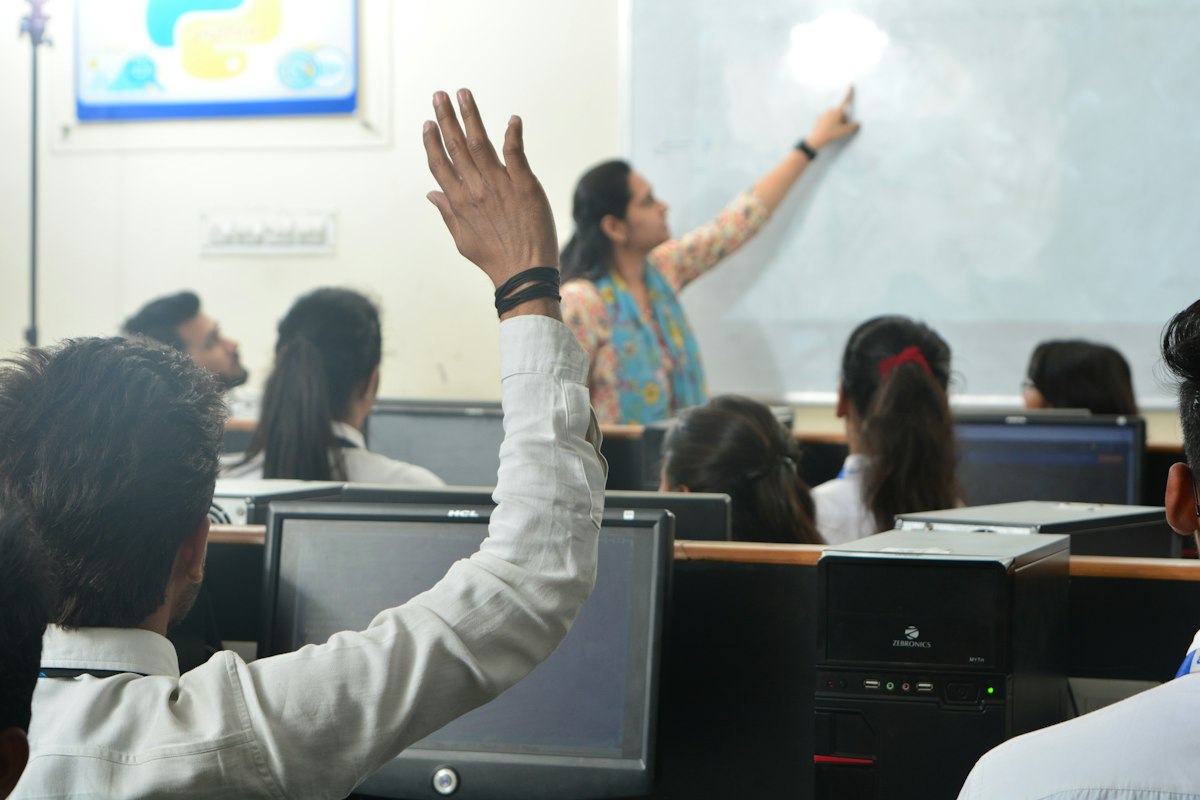 Students and a teacher in a computer classroom, representing online small-group GCSE tuition